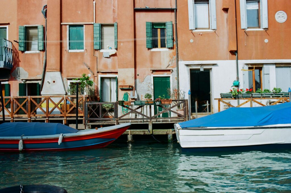 Colorful Venetian canal with traditional boats and vibrant houses.